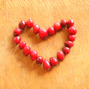 Cranberries in the shape of a heart on Cutting Board