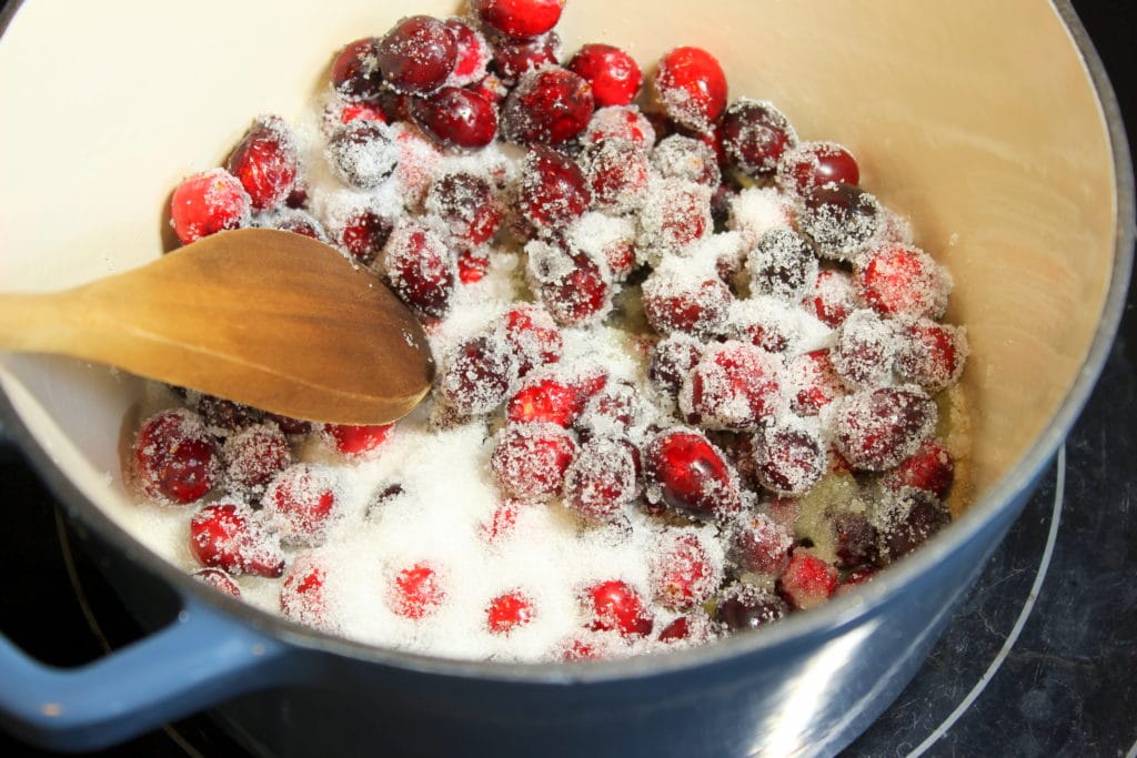 Cranberries and sugar in blue pot.