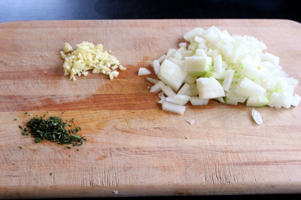 Chopped Garlic, Onion and Thyme on Wooden Board.