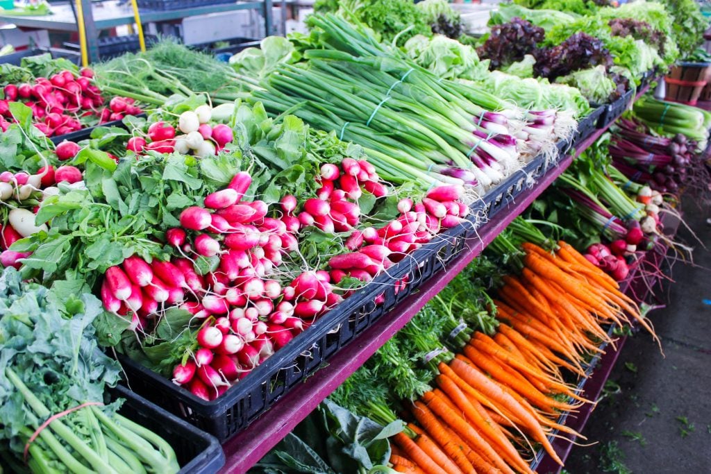 Radishes, carrots and green onions at a farmer's market stall