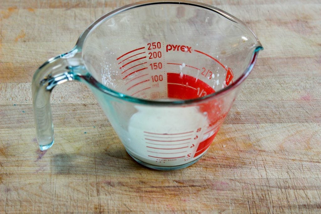 Cornstarch and water mixture in glass measuring cup.