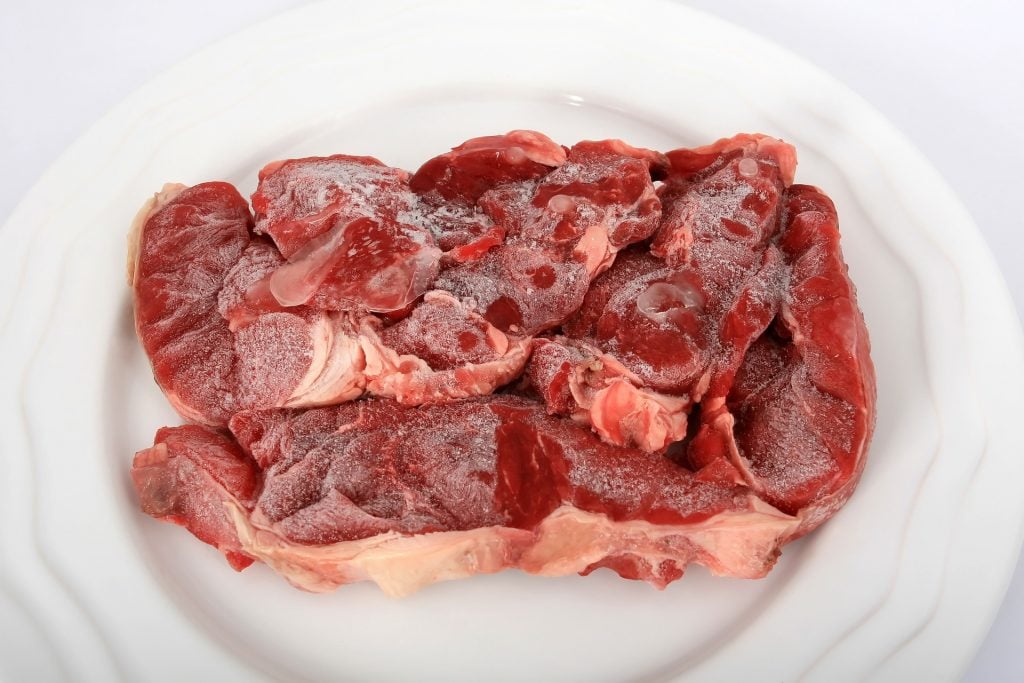 Raw beef on white plate.