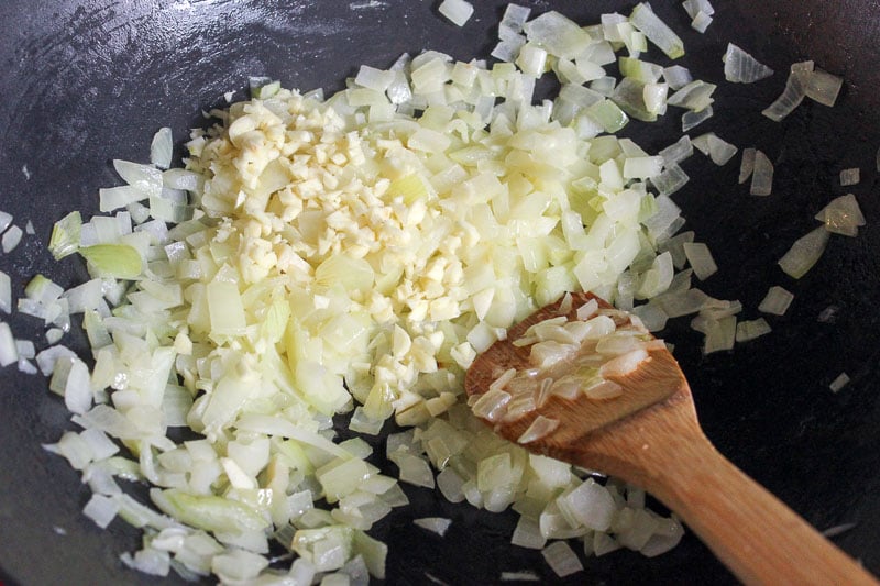Onions and garlic frying in a wok.