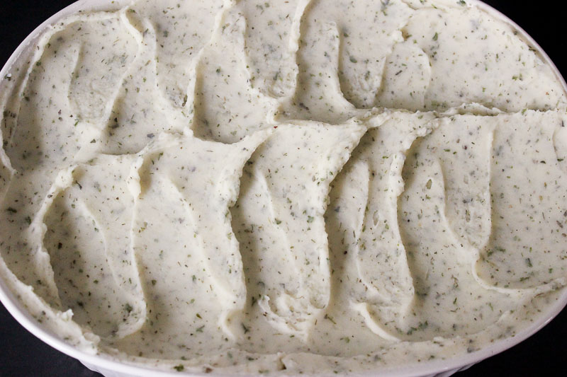 Potato, yogurt and ranch mixture in white casserole dish.