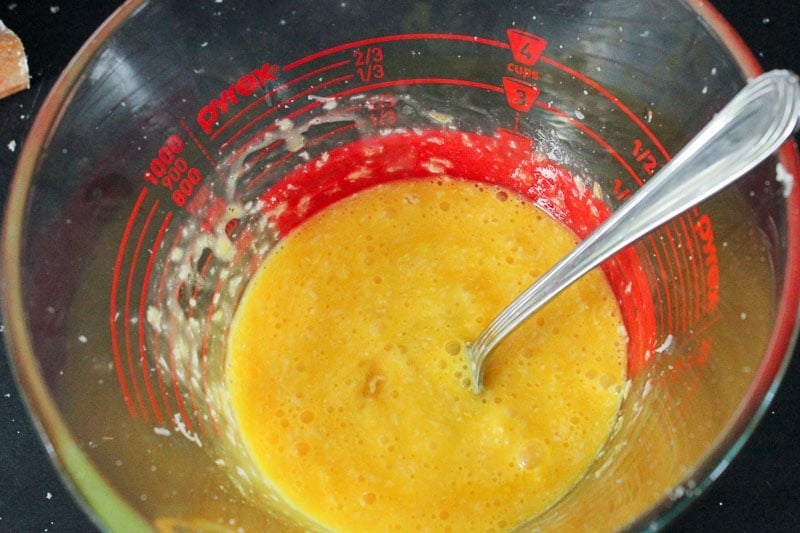 Egg and Parmesan Cheese mixture in glass measuring cup.