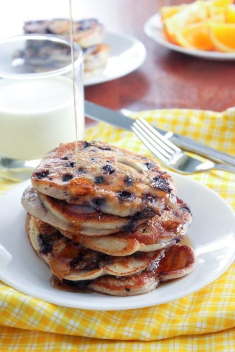 Stack of blueberry pancakes and glass of milk