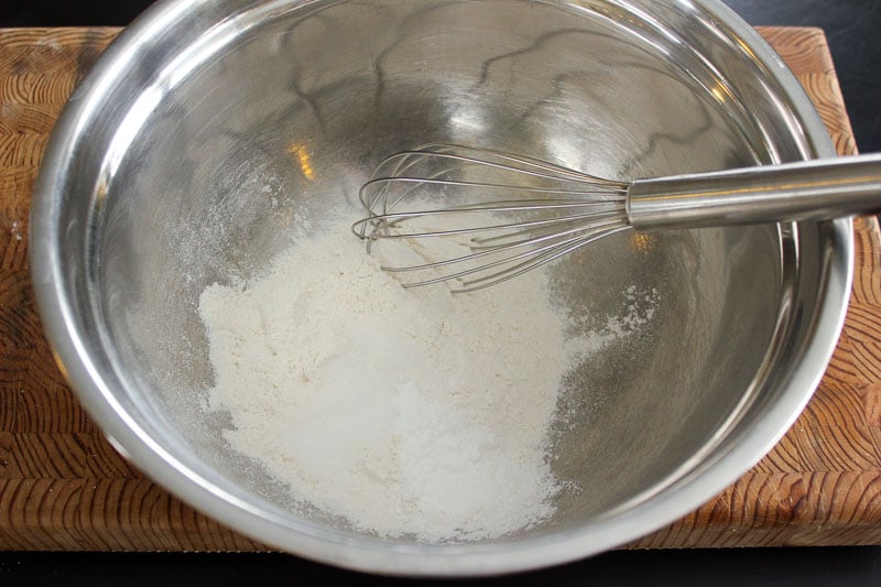 Flour, baking powder, sugar and salt in metal bowl.