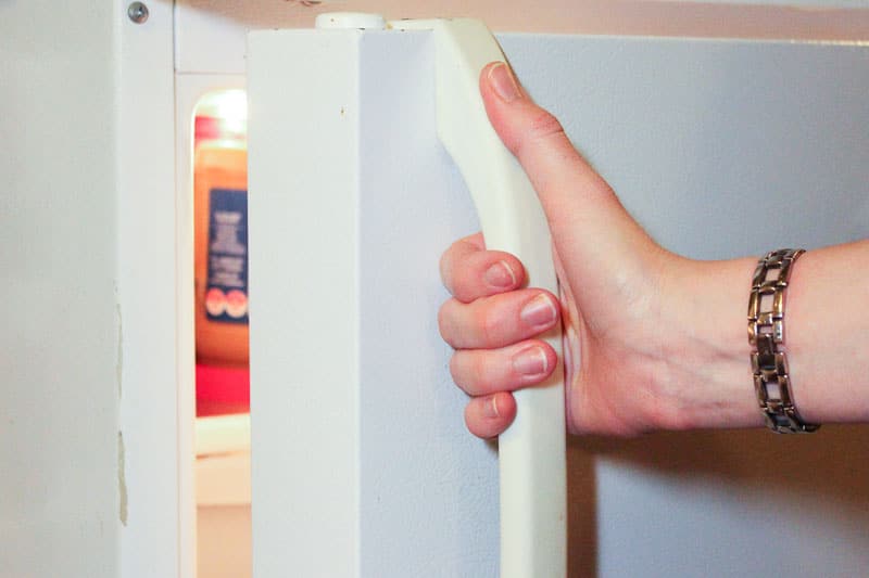 Opening a White Refrigerator Door.