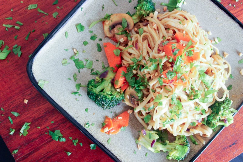 Vegetarian Dan Dan Noodles Topped with Parsley on Gray Plate.