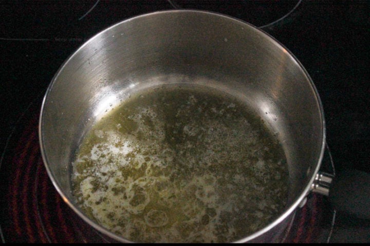 Melted butter in metal pot on stove.
