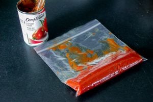 Tomato paste in small plastic bag on Black Background.