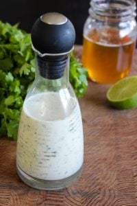 Creamy Cilantro Lime Dressing in Glass Jar with Black cover.