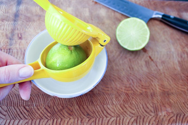 Lime in yellow citrus juicer.