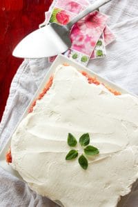 Rhubarb Tart Topped with Whipping Cream and Mint Leaves on White Square Plate.