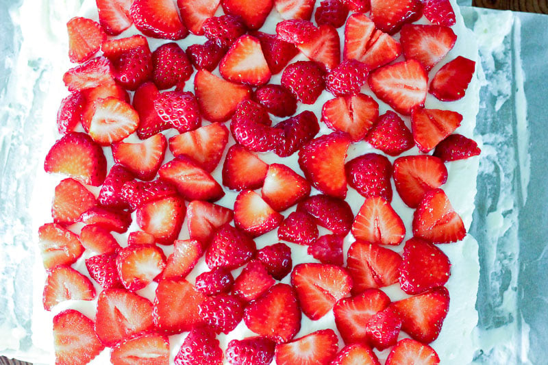 Sliced Strawberries on top of Cream Cheese Mixture.