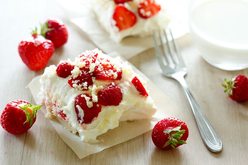 Strawberry Shortcake Bar on Parchment Paper next to fresh strawberries.