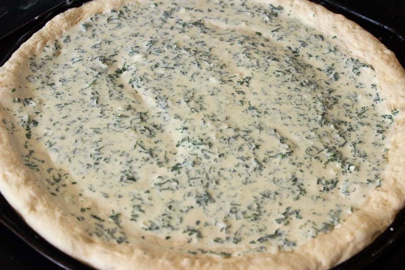 Cream Cheese and Herb Sauce on Pizza Dough.