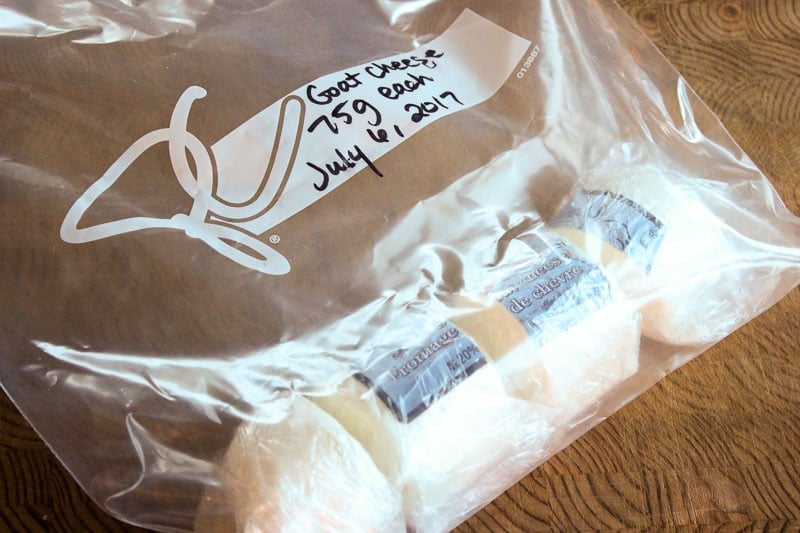 Small chunks of goat cheese wrapped in plastic wrap in freezer bag