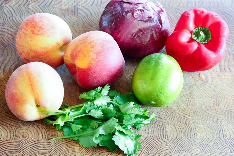 Peaches, Red Onion, Red Pepper, Lime and Cilantro on Wooden Board.