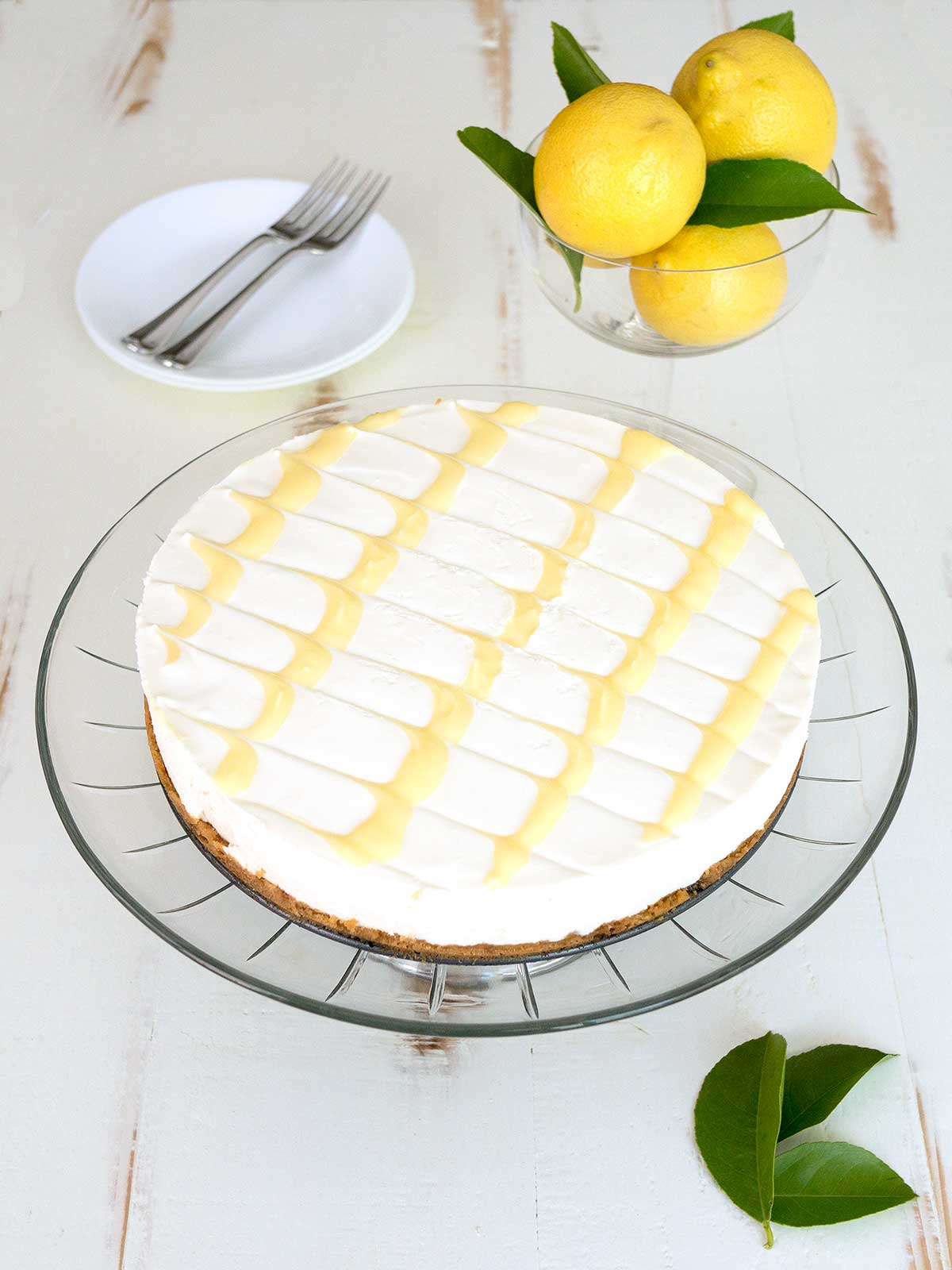 Cheesecake Topped with Lemon Curd on Glass Plate.