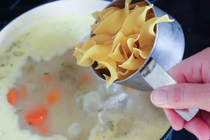 Adding Egg Noodles to Pot of Soup.