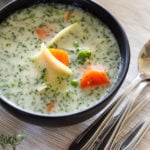 Chicken noodle soup in black bowl.