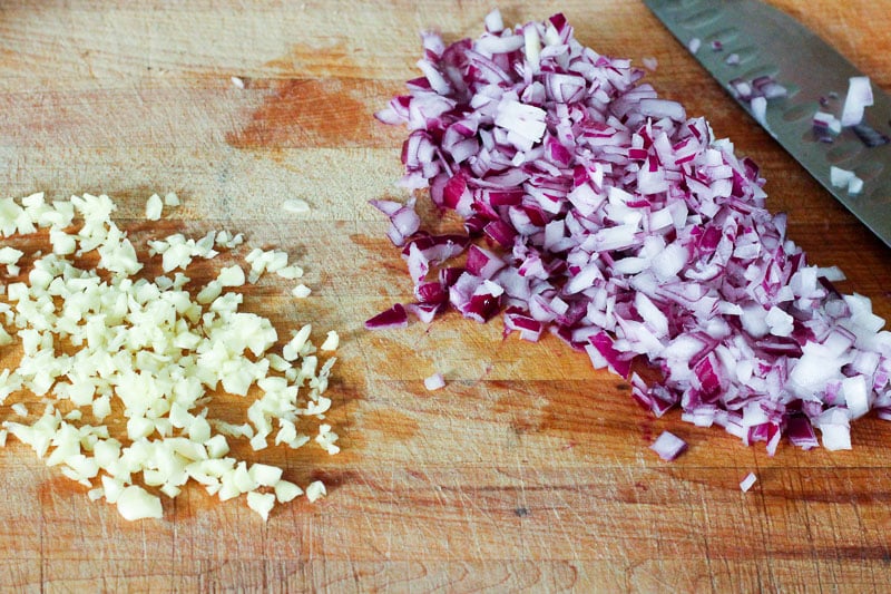 Chopped Garlic and Red Onion on Wooden Board.