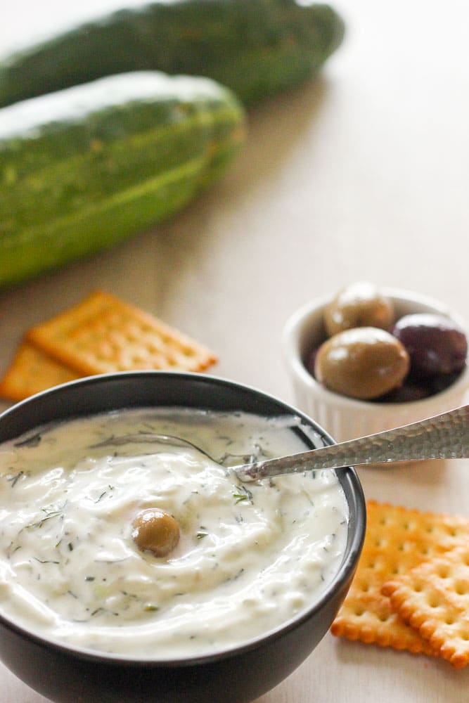 Tzatziki in Black Bowl topped with an Olive.