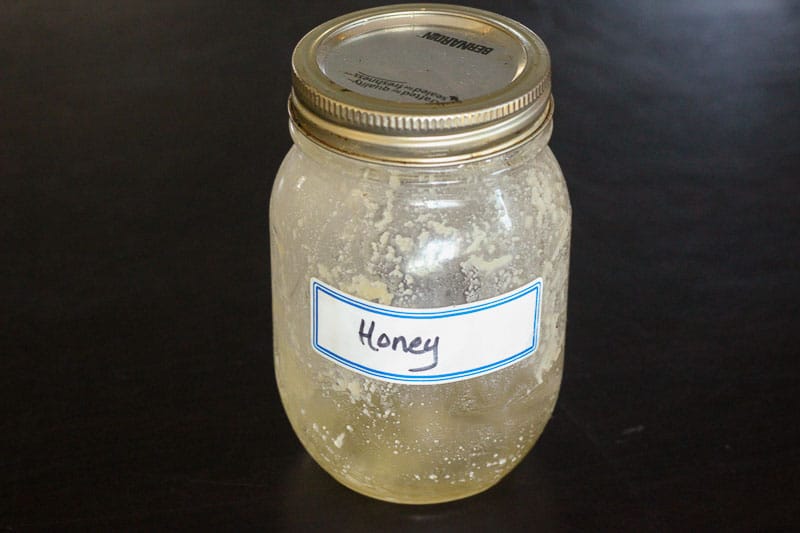 Glass Mason Jar with Honey Written on Label.