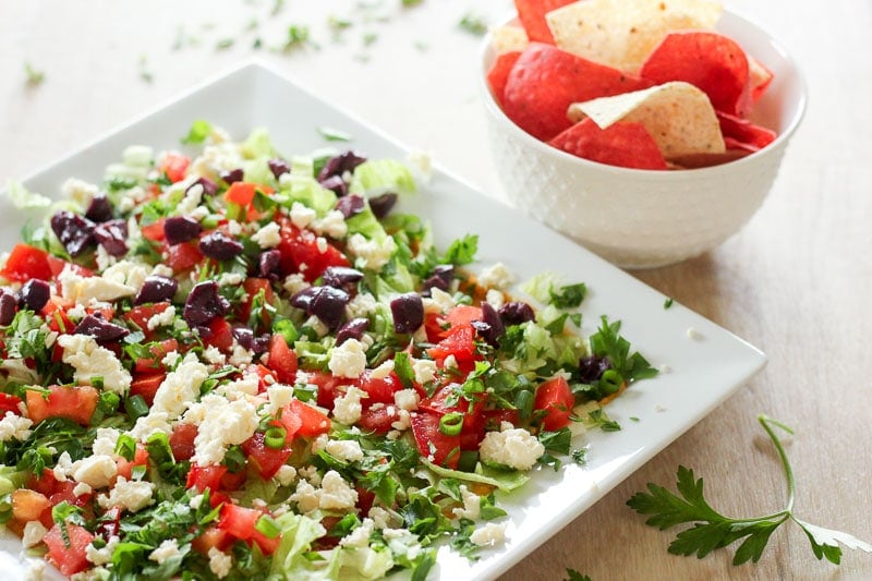 Mediterranean Dip on White Square Dish with Bowl of Red and White Nacho Chips.