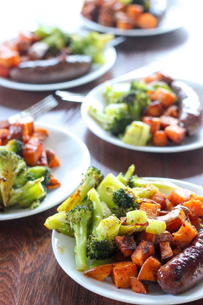 Sausages, Cajun Sweet Potatoes and Chopped Broccoli on White Plates.
