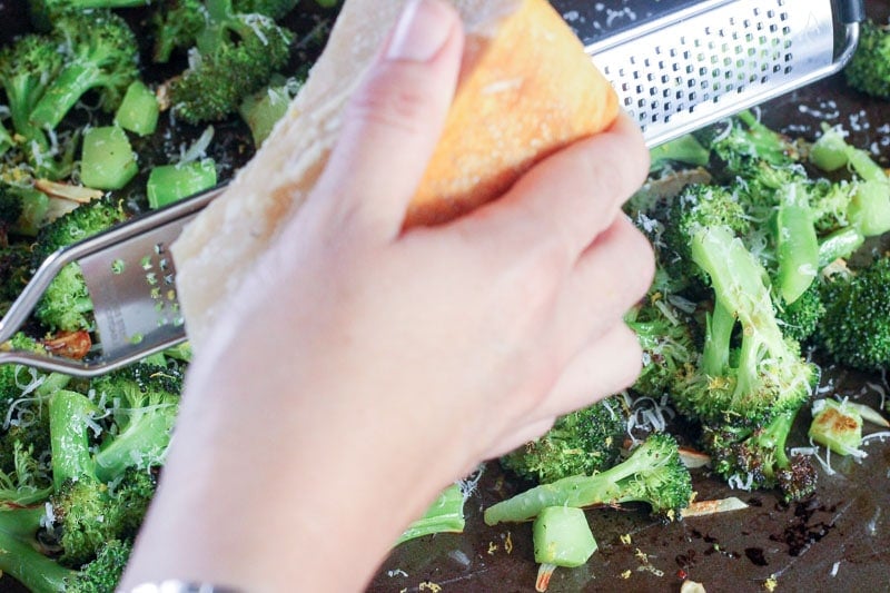 Grating Fresh Parmesan onto Oven Roasted Broccoli.