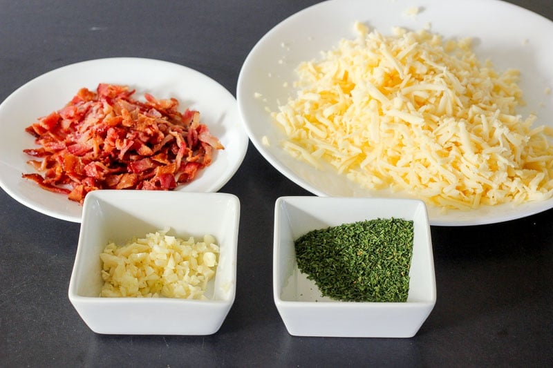 Chopped Bacon and Garlic, Shredded Cheese and Herbs in White Dishes.