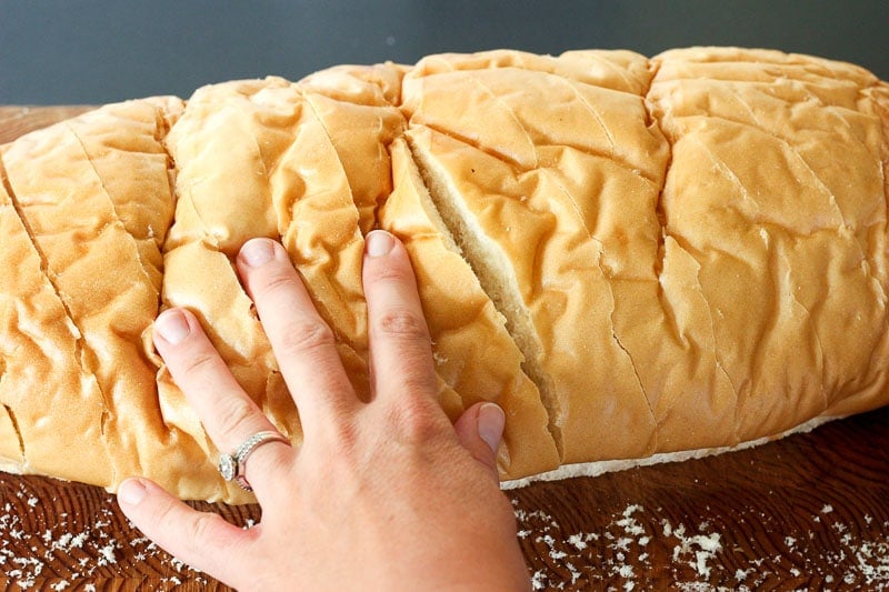 Hand Touching Sliced Loaf on Bread.