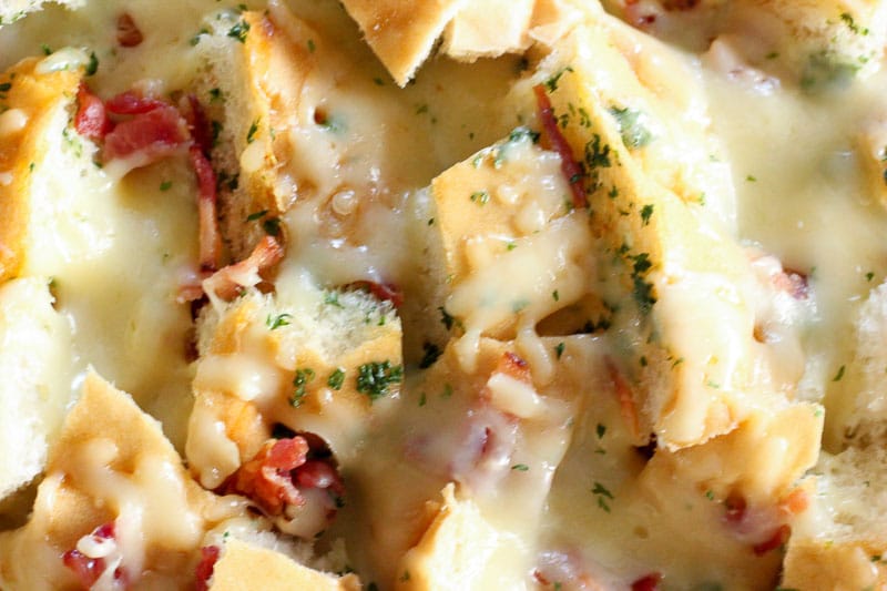 Close-up of Bread topped with Bacon, Cheese and Parsley.