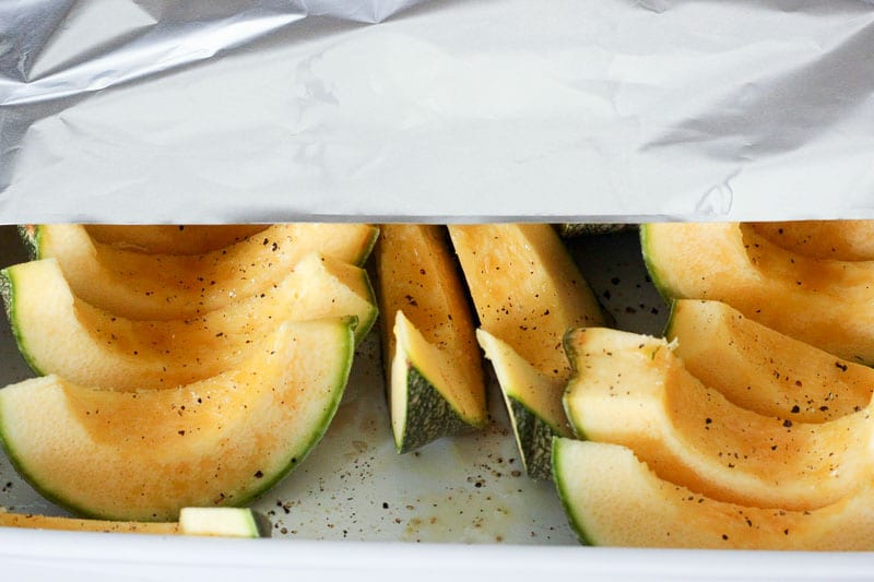Covering Sliced Squash with Aluminum Foil.