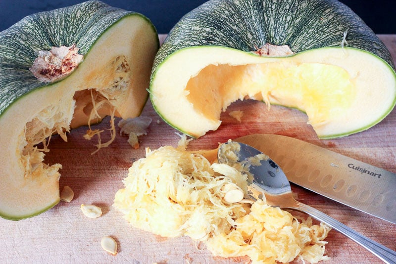 Removing Seeds from Squash on Wooden Board.