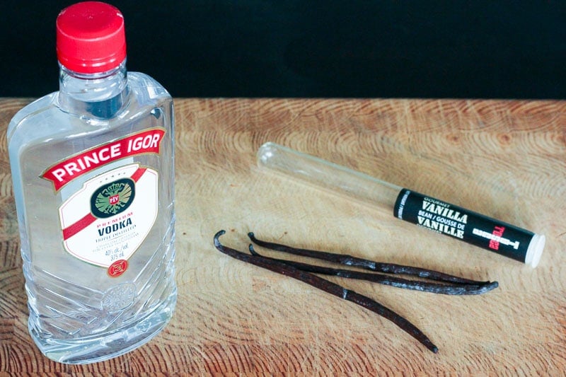 Bottle of Vodka and Vanilla Beans on Wooden Board.