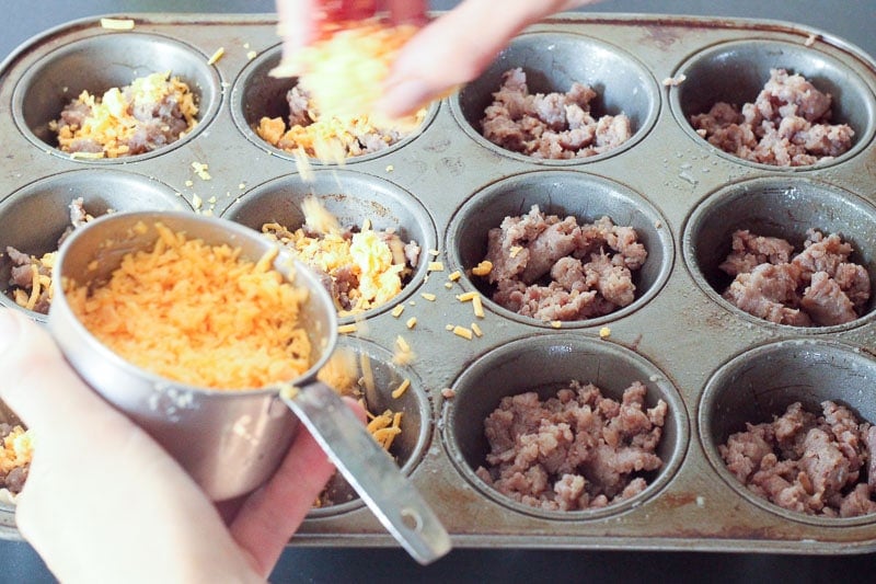 Crumbled Sausage in Muffin Pan topped with Cheddar Cheese.