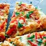 Pizza slices topped with cheese, red peppers and cilantro.