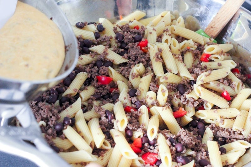 Adding Cheese Sauce to Pasta, Red Pepper and Crumbled Beef.