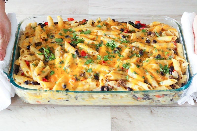 Chile Con Queso Pasta Bake topped with Parsley in Glass Baking Dish.