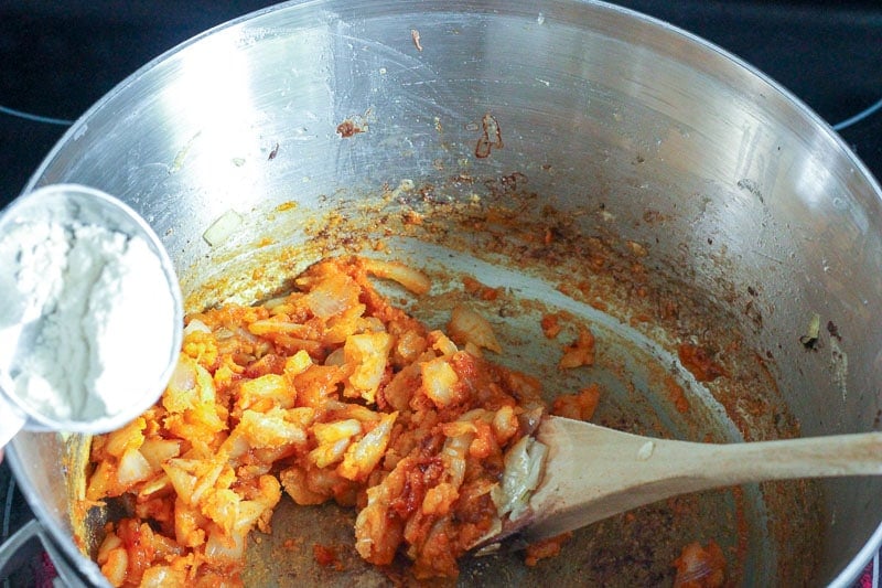 Adding flour to Fried onions and spices.