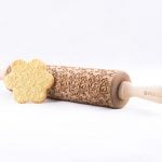Decorative Wooden Rolling Pin with Shortbread Cookie Leaning on it.