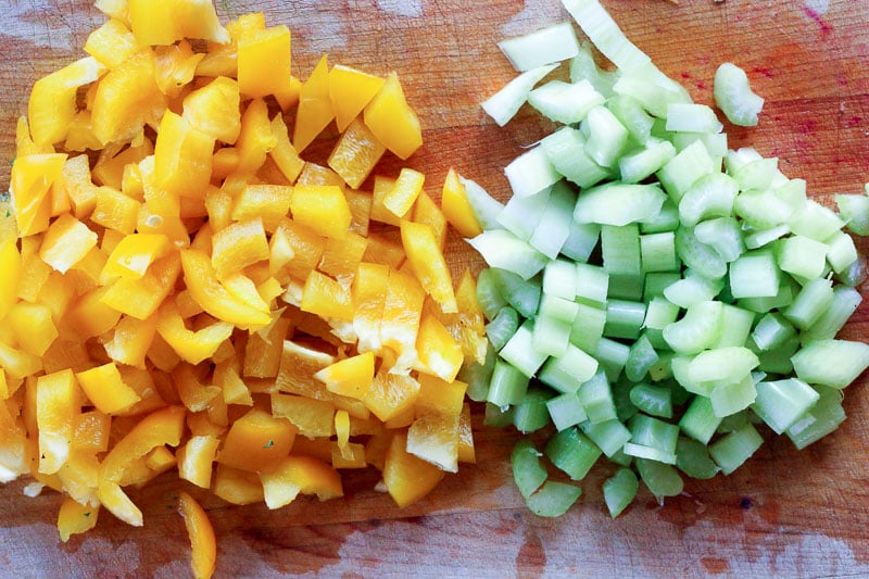 Chopped Yellow Peppers and Celery on Wooden Board.