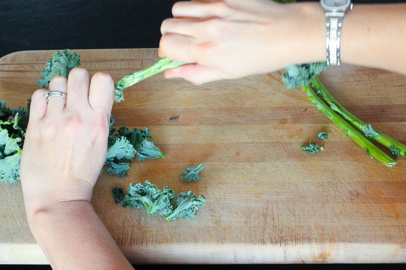 Removing kale leaves from stems.