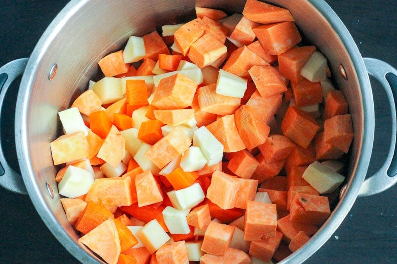Chopped Sweet Potato, Parsnip, Carrot and Turnip in Large Metal Pot.