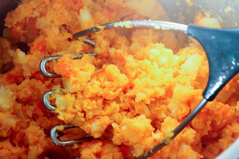 Mashing Sweet Potato, Parsnip, Carrot and Turnip with Potato Masher.