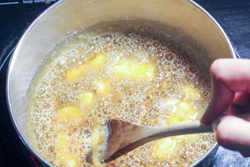 Adding Butter to Melted Sugar in Metal Pot.