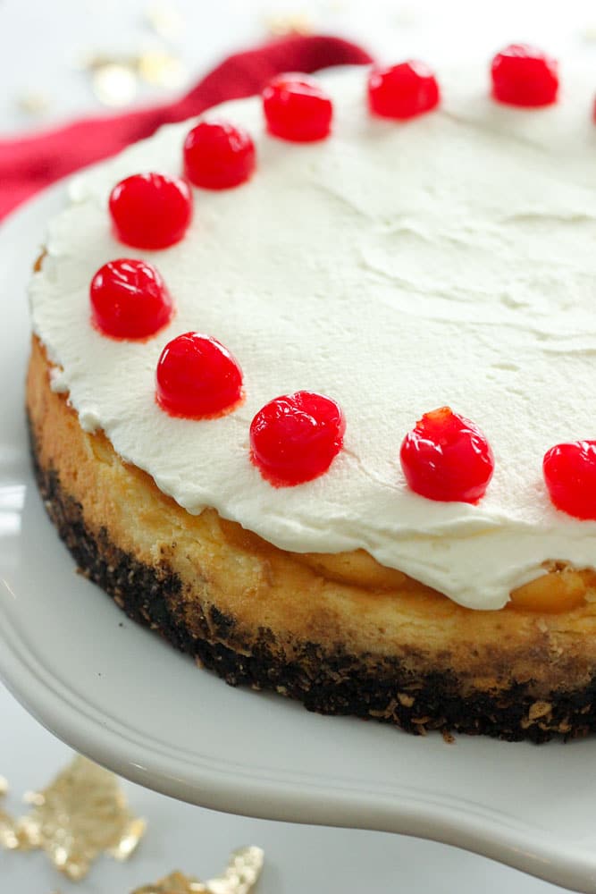 Chocolate Cherry Coconut Cheesecake topped with Whipping Cream and Cherries.
